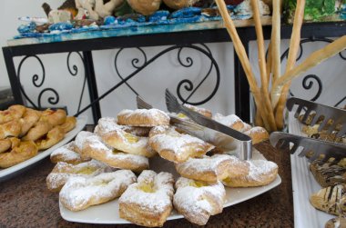 büyük masada tabaklarda tatlı çörekler çeşitli