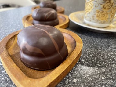 Lezzetli ev yapımı kurabiyeler ve çikolatalı şekerlemeler ahşap bir stantta, tabak, yaratıcı yaklaşım, kahve, çay tabağıyla altın kupa