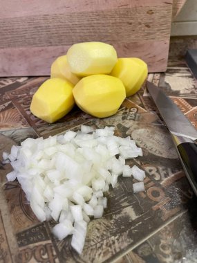 Masadaki taze sebzeler: soyulmuş çiğ patates ve doğranmış soğan. Çorba, sebze yahnisi.