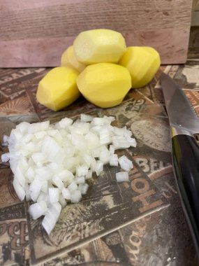 Masadaki taze sebzeler: soyulmuş çiğ patates ve doğranmış soğan. Çorba, sebze yahnisi.