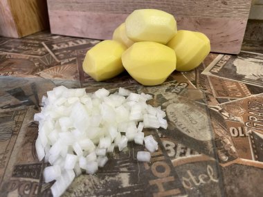 Masadaki taze sebzeler: soyulmuş çiğ patates ve doğranmış soğan. Çorba, sebze yahnisi.