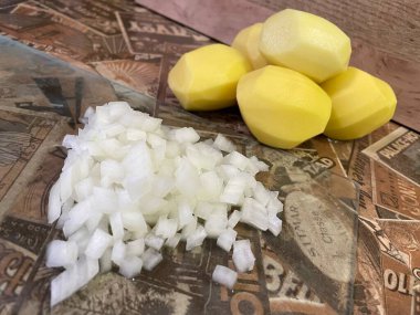 Masadaki taze sebzeler: soyulmuş çiğ patates ve doğranmış soğan. Çorba, sebze yahnisi.