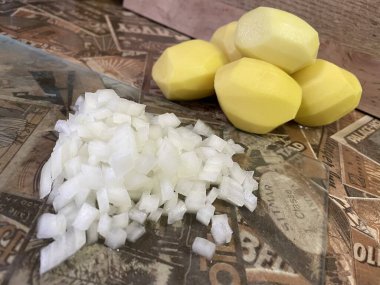 Masadaki taze sebzeler: soyulmuş çiğ patates ve doğranmış soğan. Çorba, sebze yahnisi.