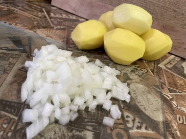 Masadaki taze sebzeler: soyulmuş çiğ patates ve doğranmış soğan. Çorba, sebze yahnisi.