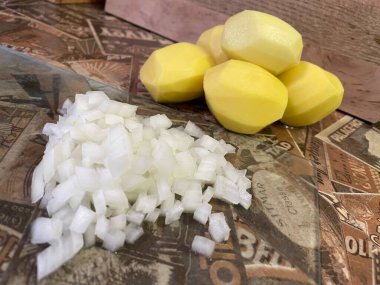 Masadaki taze sebzeler: soyulmuş çiğ patates ve doğranmış soğan. Çorba, sebze yahnisi.