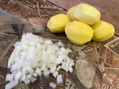 Masadaki taze sebzeler: soyulmuş çiğ patates ve doğranmış soğan. Çorba, sebze yahnisi.