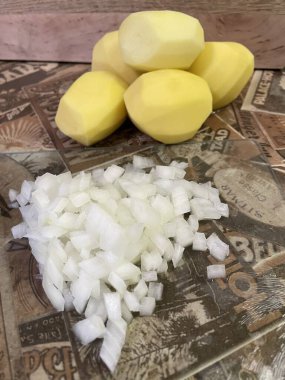 Masadaki taze sebzeler: soyulmuş çiğ patates ve doğranmış soğan. Çorba, sebze yahnisi.