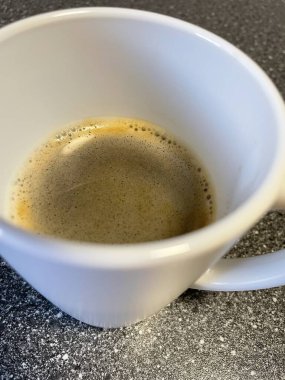 Siyah arka planda bir fincan kahvenin yakın plan çekimi.