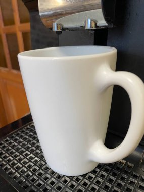 Siyah bir masada beyaz kahve fincanı.