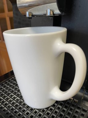 Beyaz bir fincan sıcak kahvenin yakın plan fotoğrafı.