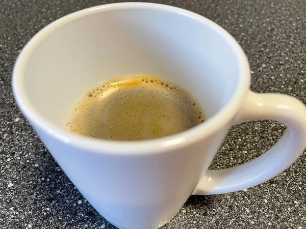 Sıcak bir içecekle beyaz bir fincanın yakın çekimi.