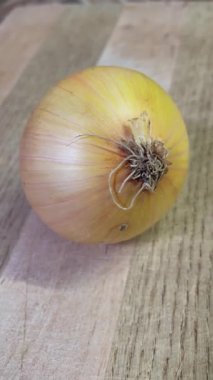 Tahta zemin üzerinde taze organik soğanlar; sebzeler