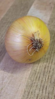 Tahta zemin üzerinde taze organik soğanlar; sebzeler