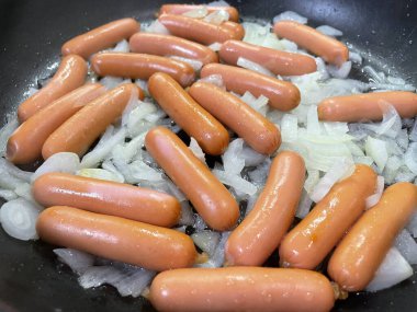 Kızartma tavasında sosis pişirmek.