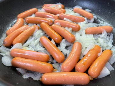 Tavada taze çiğ sosis.