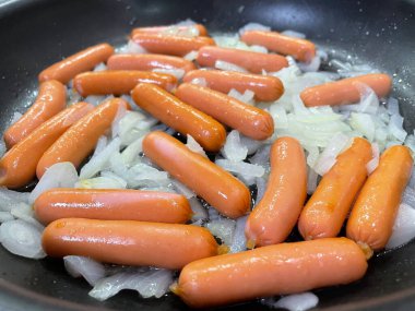 Fırında pişen taze sosisler.