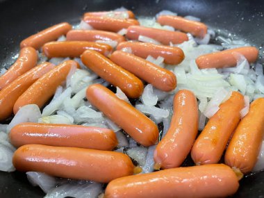 bir tavada kızarmış sosis