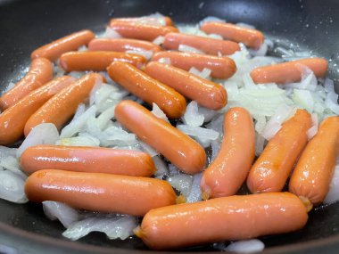 Taze ve sıcak sosisler tavada.