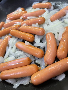 Izgarada taze sosisler. Tavada sosis pişirmek. Barbeküde yemek pişirmek