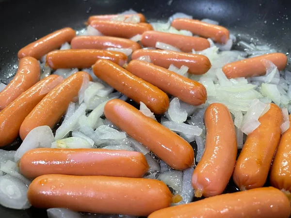 Taze ve lezzetli sosisler tavada.