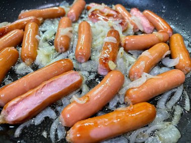 Tavada kızarmış tavuk ve sosis.