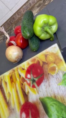 Tahta bir masada sebzeler, domatesler ve salatalıklar.