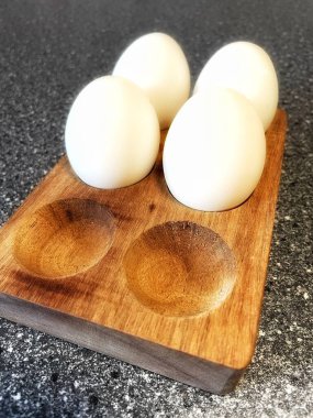 Tahta arka planda bir kasede yumurtalar