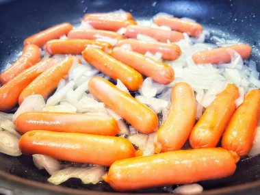 Tavada kızartılmış soğanlı sosisler, evde pişirme, hızlı kahvaltı.