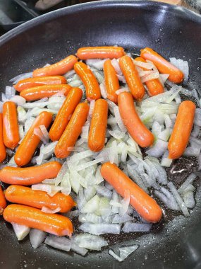 Tavada kızartılmış soğanlı sosisler, evde pişirme, hızlı kahvaltı.