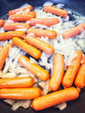 Tavada kızartılmış soğanlı sosisler, evde pişirme, hızlı kahvaltı.