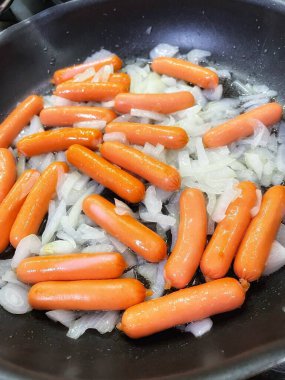 Tavada kızartılmış soğanlı sosisler, evde pişirme, hızlı kahvaltı.