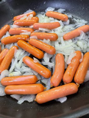 Tavada kızartılmış soğanlı sosisler, evde pişirme, hızlı kahvaltı.