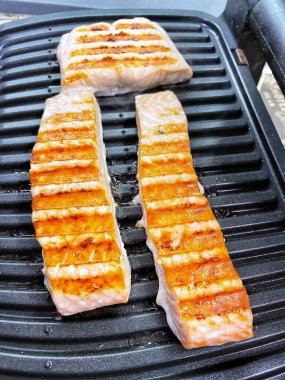 Sokakta lezzetli bir ızgara somon balığı yakın.