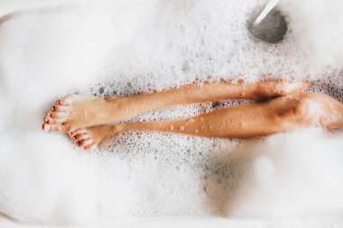 Kadın bacaklar banyo köpük. Üstten görünüm. Zevk ve rahatlama spa otel