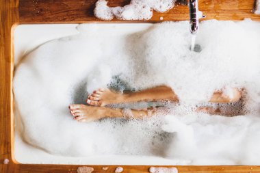 Kadın bacaklar banyo köpük. Üstten görünüm. Zevk ve rahatlama spa otel