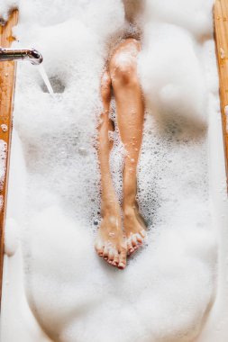 Kadın bacaklar banyo köpük. Üstten görünüm. Zevk ve rahatlama spa otel