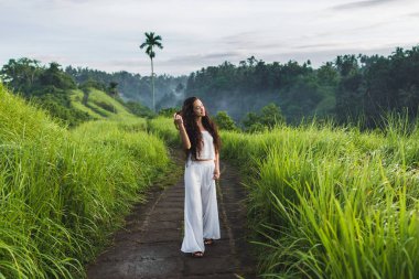 Campuhan Ridge Way sanatçıların, Bali, Ubud poz uzun kıvırcık saçlı kadın.