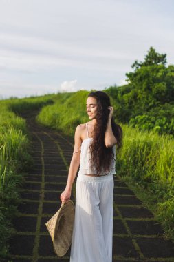 Campuhan Ridge sanatçılar, Ubud, Bali yolda yürürken beyaz elbiseli Genç kadın portresi.