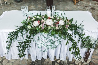 Beyaz düğün tablo yeşil çiçek Aranjman pembe şakayık çiçekleri ve çatal bıçak takımı, rustik tarzı ile dekore edilmiştir.