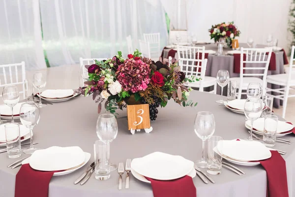 stock image Wedding tables decorated with red flowers bouquets and grey tablecloths with white plates