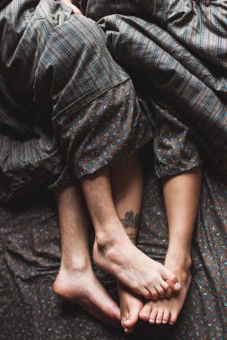Sabah, romantik ruh hali kavramı birlikte yatakta yatan genç çiftin bacaklar 