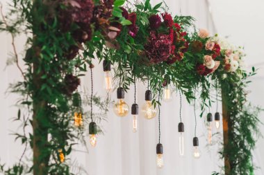 Resepsiyon dekorasyon elektrik edison ampul ve taze kırmızı çiçeklerle, rustik tarzı düğün