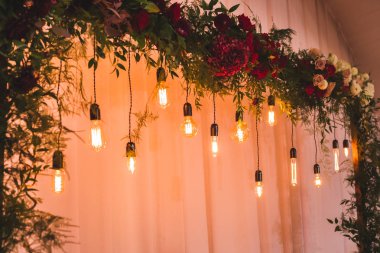 Resepsiyon dekorasyon elektrik edison ampul ve taze kırmızı çiçeklerle, rustik tarzı düğün