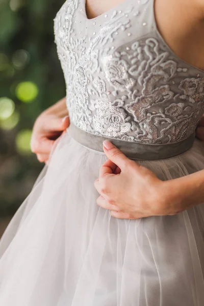 身穿灰色时尚丝绸婚纱的女士用花边和珠子绣上了号角 — 图库照片