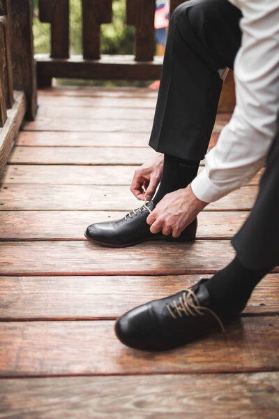 Man in black trousers and white shirt wearing brown leather classic shoes , business style concept 