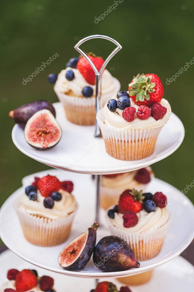 Fresh tasty cupcakes with berries on wedding reception table 