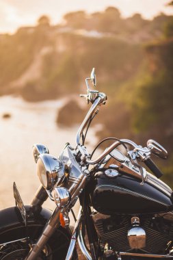 Eski sıcak güneşin altında uçurumun kenarında üzerinde gündoğumu, Bisiklet yakın çekim parlak ayrıntılarını duran vintage motosiklet