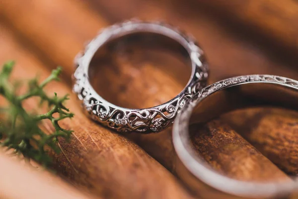Wedding rings on cinnamon sticks texture close-up