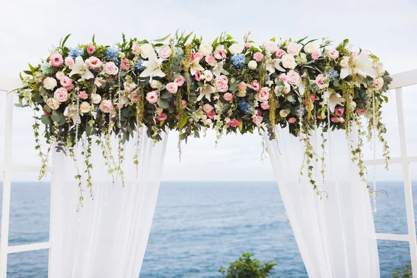 結婚式は明るい白い色調 木製アーチ花の装飾で海を見渡せる崖の上 — ストック写真