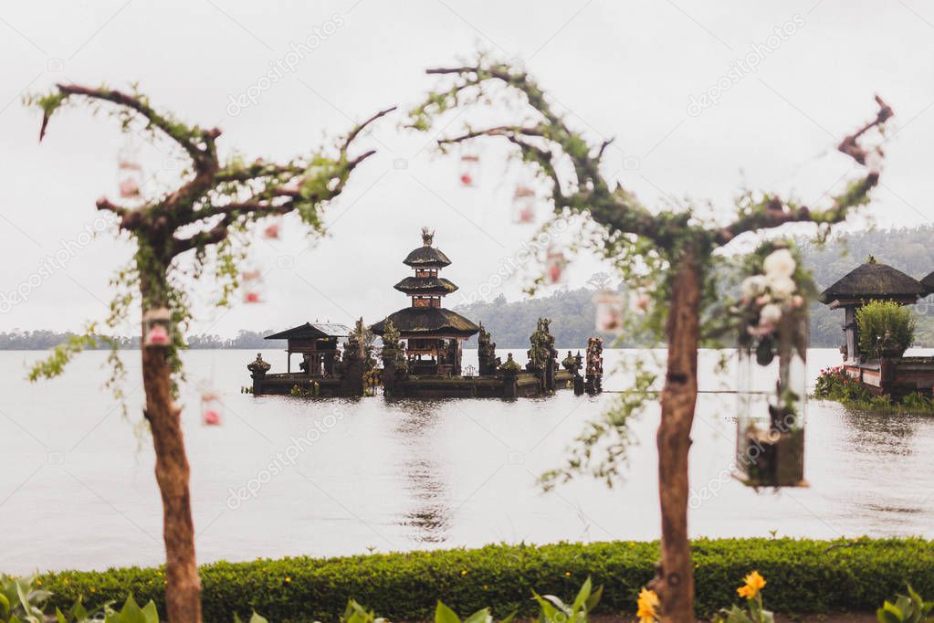 Wedding ceremony at Ulun Danu Bratan temple in Bali. Decorated with wood, flowers and vintage lamps